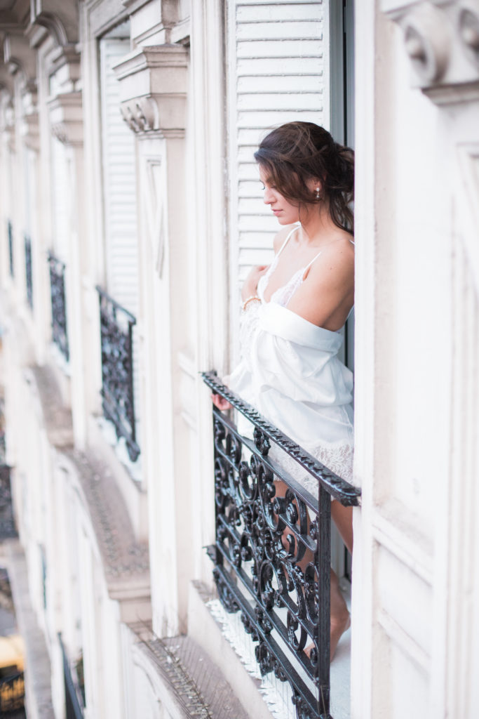Vrouw in bruidskleding op een balkon in de stad Parijs